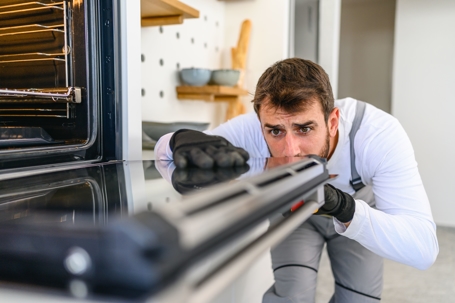 man trying to figure out why oven is not heating properly